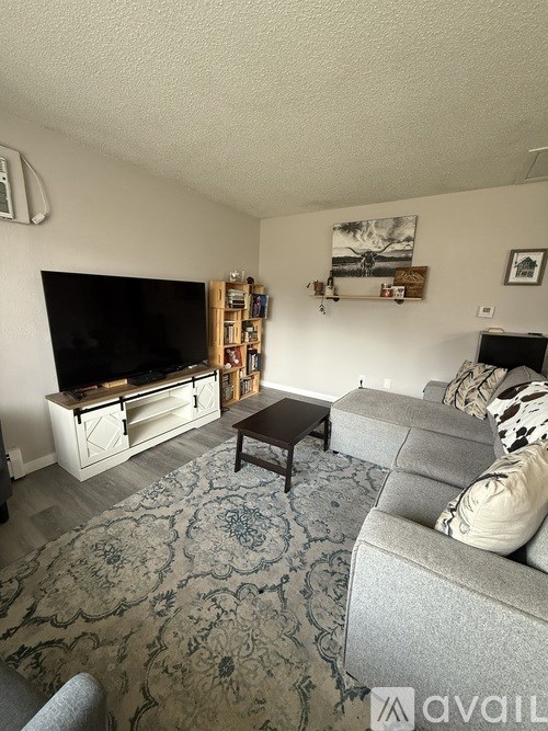 A living room with a grey couch and a wooden coffee table.