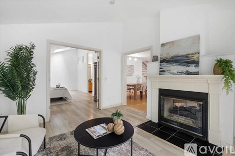 A living room with a fireplace and a painting on the wall.
