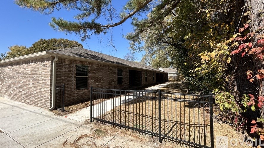 A house with a black fence and a brick wall.