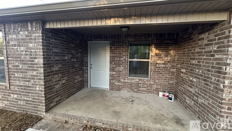 A brick house with a white door and a window.