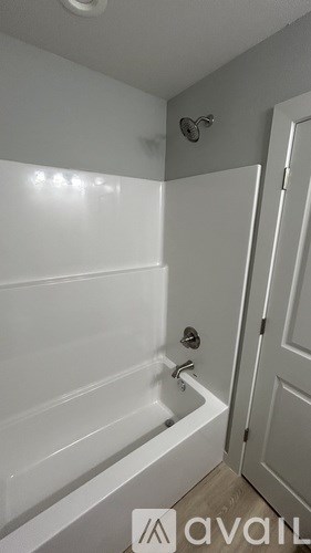 A white bathroom with a tub and a door.