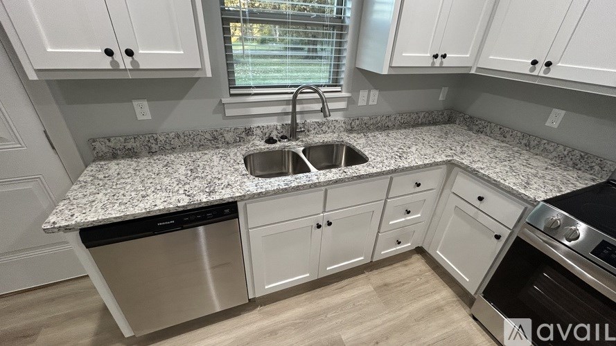 A kitchen with a granite countertop and stainless steel appliances.