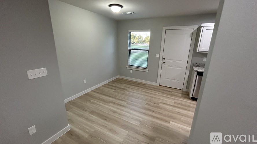 A room with wooden flooring and a white door.