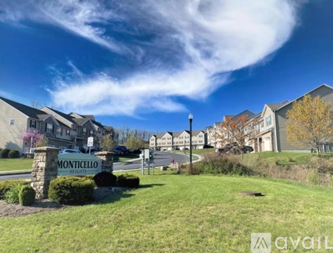 A sign for Monticello Heights in front of a row of houses.