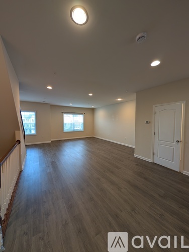 A room with wooden flooring and a white door.