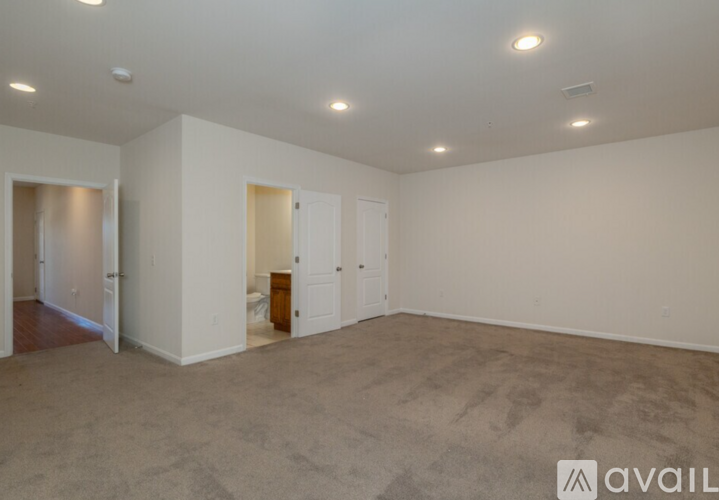 Empty room with white walls and carpeted floor.