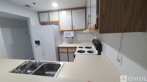 A kitchen with a stove, sink, and refrigerator.