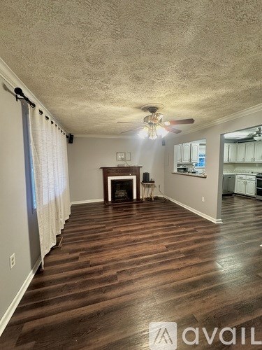 A living room with a fireplace and wood flooring.