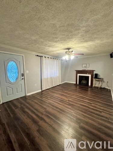 A room with wooden flooring and a fireplace.
