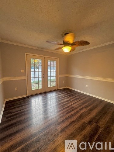 A room with wooden floors and a ceiling fan.
