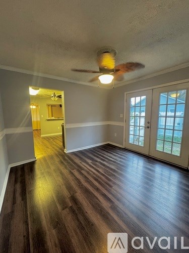 A room with wooden floors and a ceiling fan.