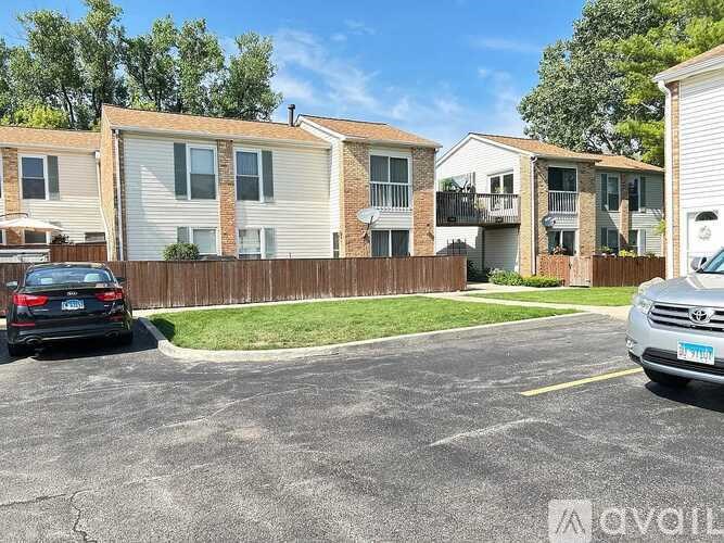 A parking lot with cars and apartment buildings in the background.