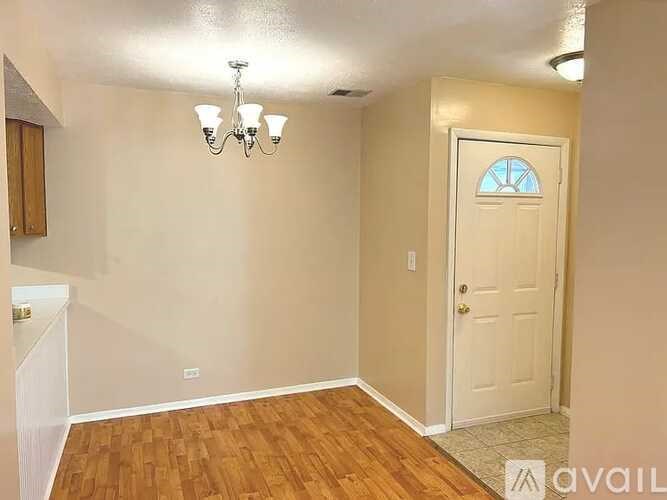 A room with a wooden floor and a white door.