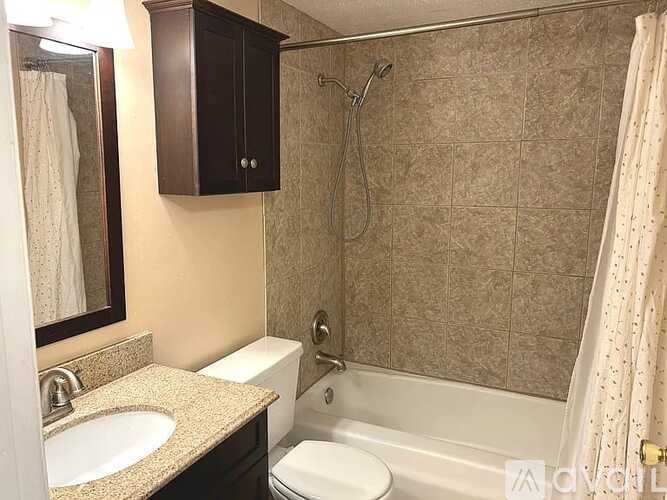 A bathroom with a toilet, sink, and bathtub.