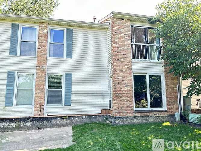 A two-story house with a balcony on the second floor.