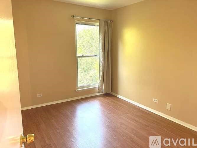 A room with a window and wooden flooring is available for rent.