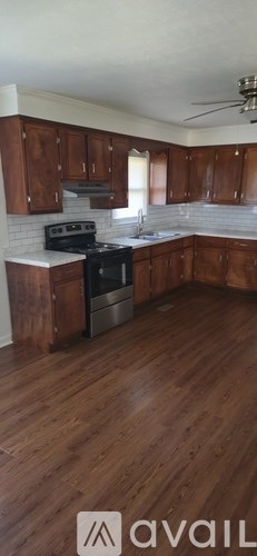 A kitchen with wooden cabinets and a black stove top oven.