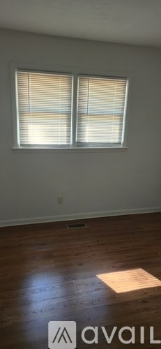 A room with a window and wooden flooring.