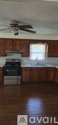 A kitchen with wooden cabinets and a stove top oven.