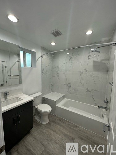A bathroom with a marble wall and a white toilet.