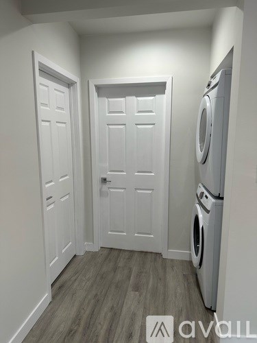 A small laundry room with a washer and dryer built into the wall.