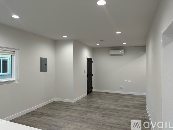 A room with a wooden floor and a black door.