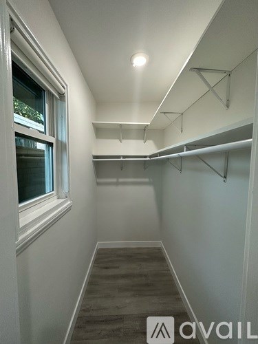 A long hallway with a window on the left and shelves on the right.