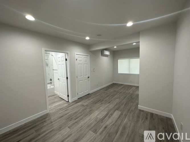 A room with wooden flooring and white walls.