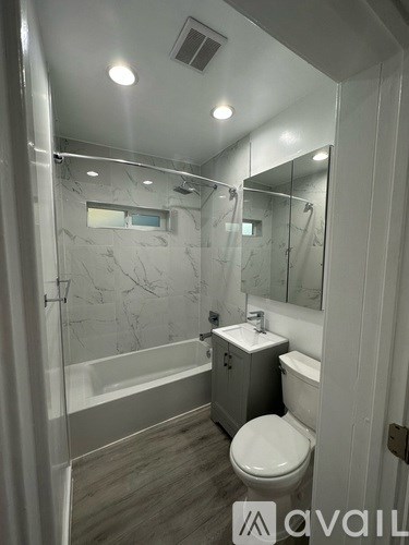A bathroom with a toilet, sink, and walk-in shower.