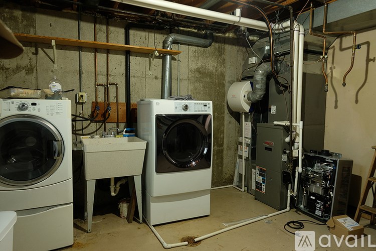 A laundry room with two washing machines and a dryer.
