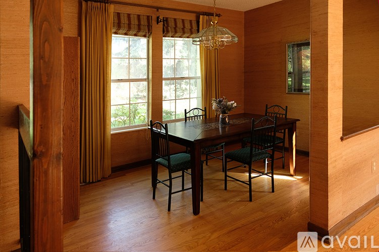 A wooden dining room with a table set for four.