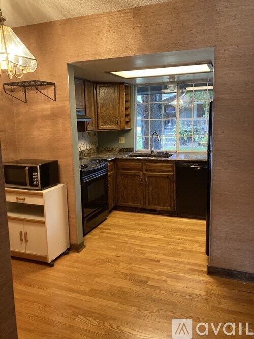 A kitchen with wooden floors and a window.