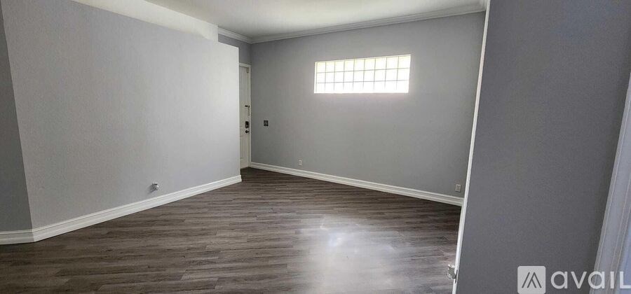 A room with wooden flooring and a window.
