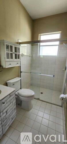 A bathroom with a toilet, sink, and shower.