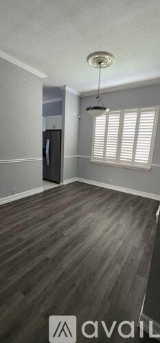 A room with wooden flooring and a black door.