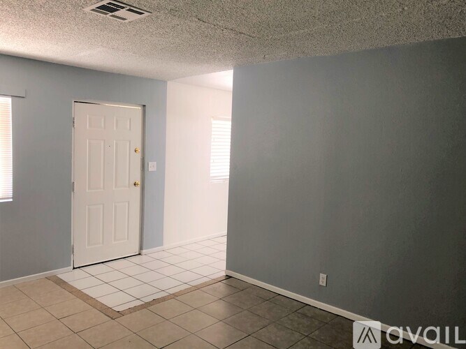 A room with a white door and a tiled floor.