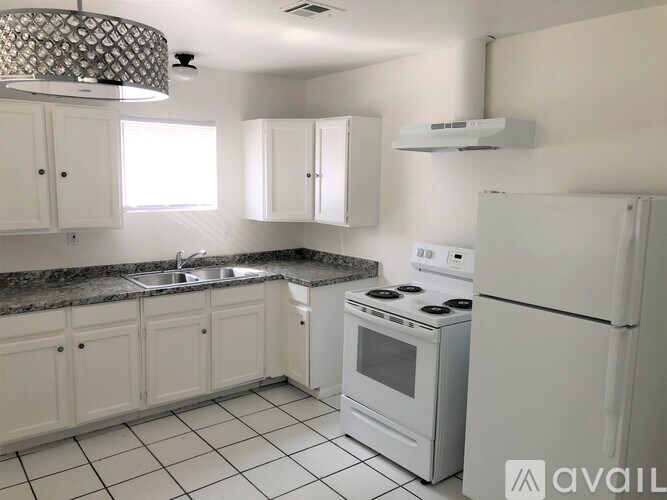 A kitchen with white appliances and cabinets.