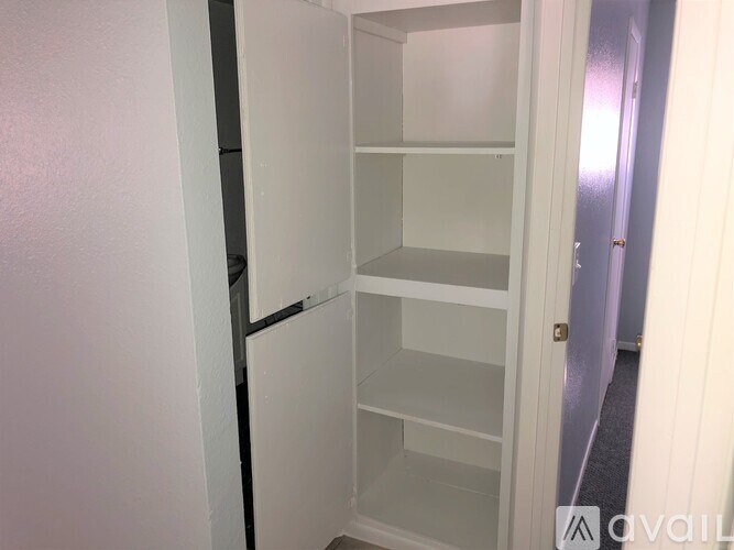A white refrigerator with its door open in a room.