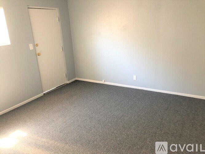 A room with a carpeted floor and a door.