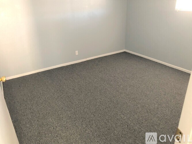 A room with grey carpet and white walls.