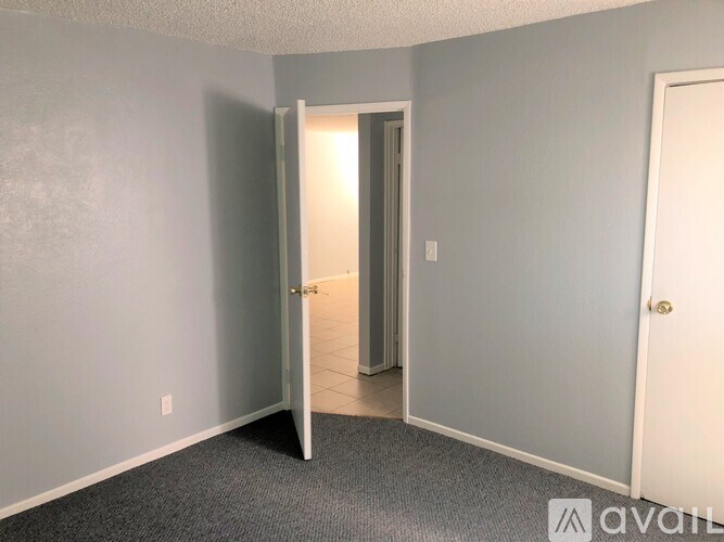 A room with a carpeted floor and a white door.