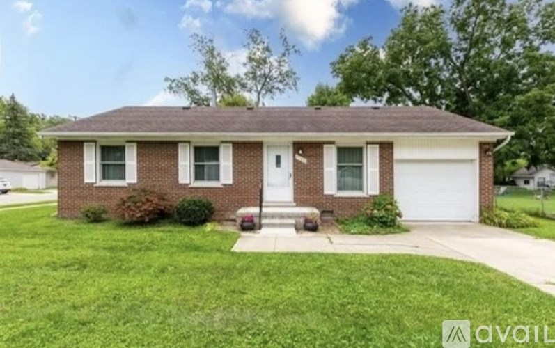 A house with a brown roof and a white garage door is for sale.