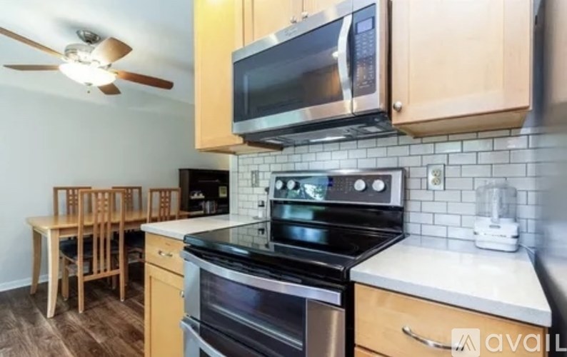 A kitchen with a stove top oven, microwave, and a table with chairs.