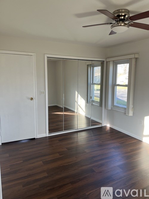 A room with a ceiling fan and a sliding glass door.