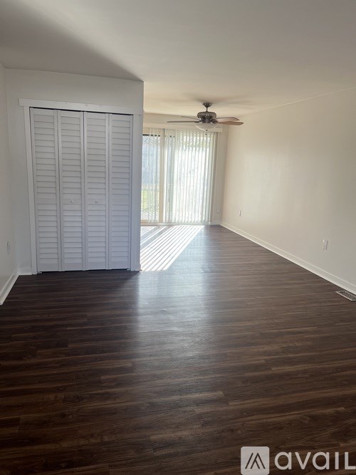 A living room with a couch, a chair, a table, a lamp, a plant, a television, and a rug.