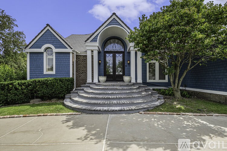 A blue house with a white door and steps leading up to it.