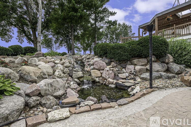 A rocky garden with a small pond and a stone pathway.