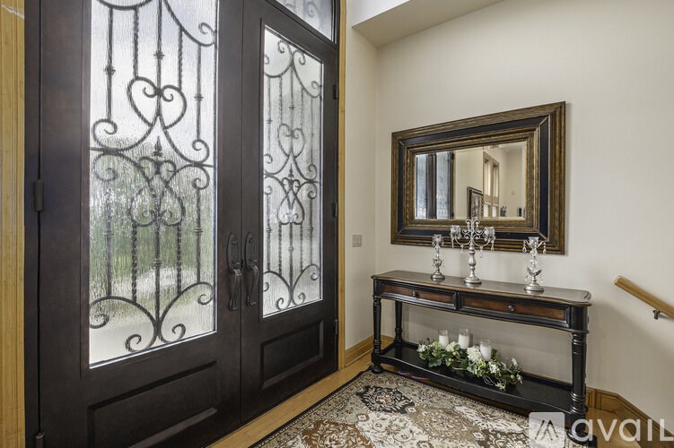 A room with a glass table and a mirror on the wall.