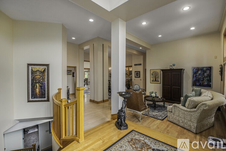 A living room with a couch, a chair, a table, and a painting on the wall.