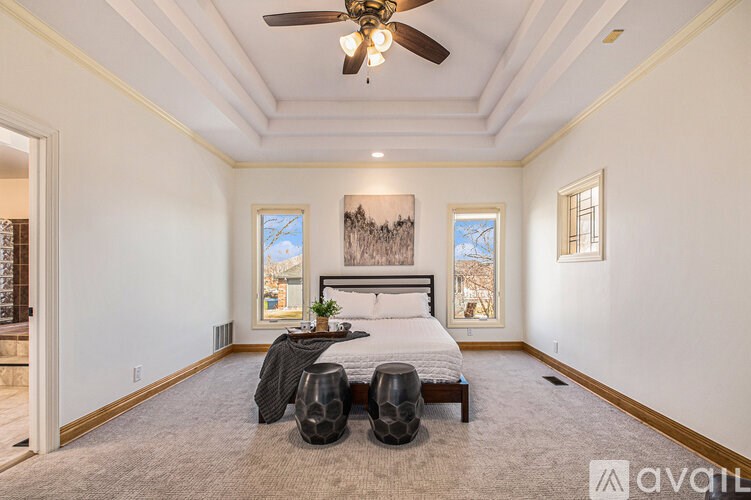 A bedroom with a large bed and a ceiling fan.